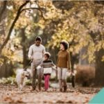 A family walking a dog through the woods